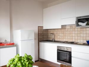 uma cozinha com armários brancos e um forno com placa de fogão em Holiday Home Orizzonte by Interhome em Marina dʼAndora