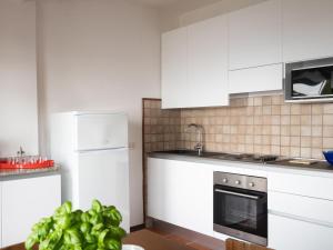 a kitchen with white cabinets and a stove top oven at Holiday Home Orizzonte by Interhome in Marina dʼAndora