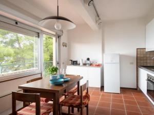 uma cozinha com uma mesa e cadeiras e um frigorífico em Holiday Home Orizzonte by Interhome em Marina dʼAndora