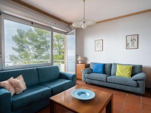 a living room with two blue couches and a table at Holiday Home Orizzonte by Interhome in Marina dʼAndora +14 photos
