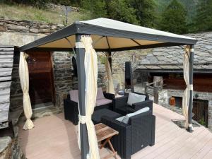 un gazebo con divano e sedie sotto di Chalet Bildji by Interhome a Staldenried