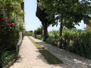 un chemin à travers un jardin avec des roses dans l'établissement Apartment Villa Palma - LBN405 by Interhome, à Labin