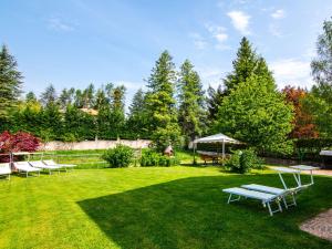 un cortile verde con sedie e tavolo da picnic di Apartment Pensione Villa Belfiore-1 by Interhome a Ronzone