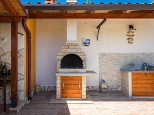 an outdoor kitchen with a stone oven in a house at Holiday Home Verbanac - LBN351 by Interhome in Labin