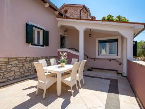 a patio with a white table and chairs at Apartment Rustica - LBN303 by Interhome in Kr&scaron;an