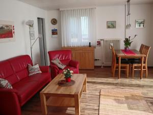 a living room with a red couch and a table at Holiday Home Mily by Interhome in Dittishausen