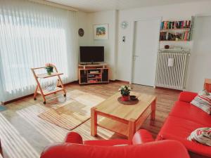 ein Wohnzimmer mit einem roten Sofa und einem Tisch in der Unterkunft Holiday Home Mily by Interhome in Dittishausen