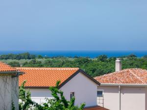 vista sui tetti delle case con l'oceano sullo sfondo di Apartment Lili-1 by Interhome a Kukci