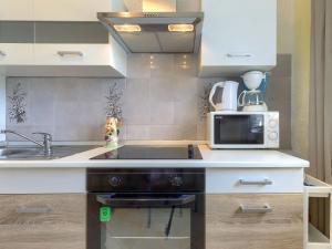 małą kuchnię ze zlewem i kuchenką mikrofalową w obiekcie Apartment Lili-1 by Interhome w mieście Kukci