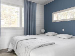 a bedroom with a large bed with blue walls at Holiday Home Villa biegga by Interhome in Kyrö