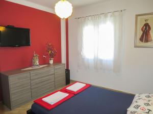 Pokój z łóżkiem i komodą z telewizorem w obiekcie Apartment Mirjana-1 by Interhome w mieście Vrsi