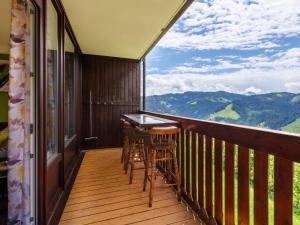 d'un balcon avec une table, des chaises et des montagnes. dans l'établissement Apartment Sonnenhang by Interhome, à Grünholzer