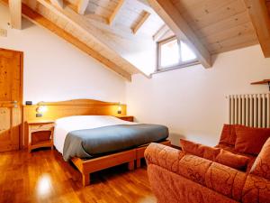 ロンツォーネにあるApartment Pensione Villa Belfiore-2 by Interhomeのベッドルーム(ベッド1台、ソファ付)