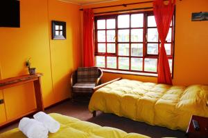 um quarto com uma cama, uma janela e uma cadeira em Hostal Torre de Babel em Castro