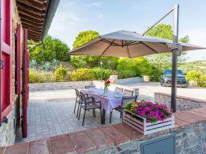 uma mesa com um guarda-chuva num pátio em Holiday Home Girasole-1 by Interhome em Montecatini Val di Cecina