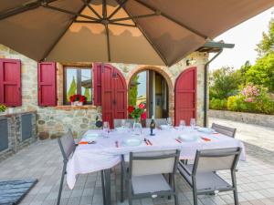 a table and chairs on a patio with red doors at Holiday Home Girasole-2 by Interhome in Montecatini Val di Cecina