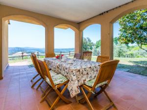 ein Esszimmer mit einem Tisch, Stühlen und Fenstern in der Unterkunft Holiday Home Podere Santa Lucia by Interhome in Volterra