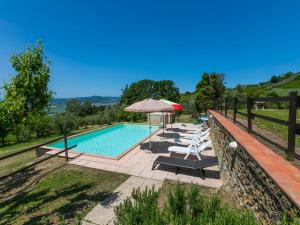 einen Pool mit Liegestühlen und einem Sonnenschirm in der Unterkunft Holiday Home Podere Santa Lucia by Interhome in Volterra