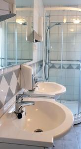 La salle de bains est pourvue de 2 lavabos et d'une douche. dans l'établissement Klostergården Bed & Breakfast, à Tautra