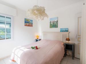 een slaapkamer met een roze bed en een raam bij Holiday Home Maison Poincaré by Interhome in Saint-Aygulf