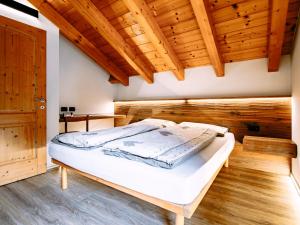 a bed in a room with wooden ceilings at Apartment Cecilia-3 by Interhome in Campitello