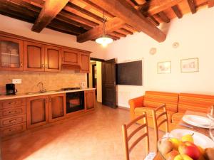 kuchnia z drewnianymi szafkami i stołem z owocami w obiekcie Apartment Pian dei Carpini - Laura by Interhome w mieście Prata