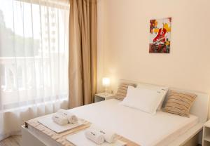 een slaapkamer met een wit bed en handdoeken bij Beautiful Apartments in a Luxury Residence in Varna in Varna