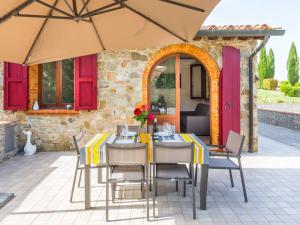 a patio with a table and chairs and an umbrella at Apartment Girasole-3 by Interhome in Montecatini Val di Cecina