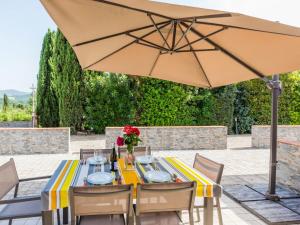 a table with an umbrella on a patio at Apartment Girasole-3 by Interhome in Montecatini Val di Cecina