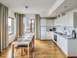 een keuken met witte kasten en een tafel met stoelen bij Holiday Home Nordic chalet 9506 by Interhome in Ylläs