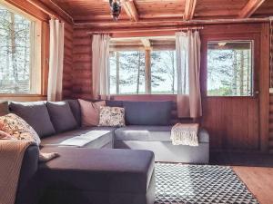 a living room with a couch and two windows at Holiday Home Haapala by Interhome in Soini
