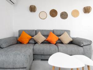 a living room with a gray couch with orange pillows at Apartment Bahia Azul in Denia