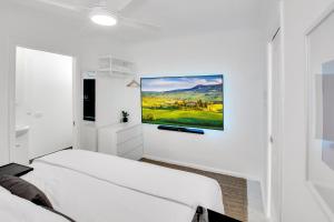a bedroom with two beds and a painting on the wall at Private Outdoor Spa, Fire Pit, Cinema Room - THE COTTAGE COOLUM BEACH in Coolum Beach
