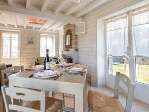 a dining room with a table with a bottle of wine at Holiday Home Zoé - CEZ407 by Interhome in Créances