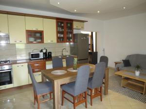 a kitchen and living room with a wooden table and chairs at Holiday Home Tina by Interhome in Biograd na Moru