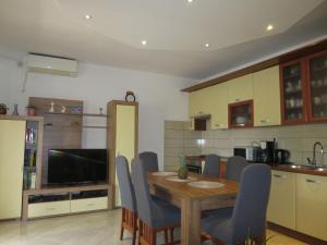 a kitchen with a wooden table and blue chairs at Holiday Home Tina - BIG120 by Interhome in Biograd na Moru