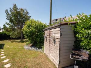 een houten buitenhuis met een stoel in een tuin bij Holiday Home La Gare by Interhome in Champeaux