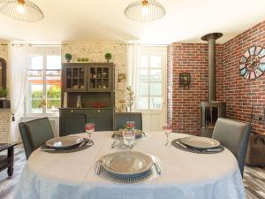 een eetkamer met een tafel en stoelen en een open haard bij Holiday Home La Gare by Interhome in Champeaux