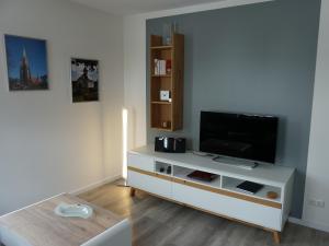 een woonkamer met een tv en een witte kast bij Apart Schleswig **** in Schleswig