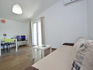 ein Wohnzimmer mit einem Sofa und einem Tisch in der Unterkunft Apartment Ivka-3 by Interhome in Tribunj