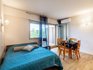 a bedroom with a bed and a table and a desk at Apartment Les Platanes-3 by Interhome in Sainte-Maxime