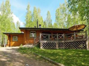 une cabane en rondins avec un parasol en face de celle-ci dans l'établissement Holiday Home Koivukallio by Interhome, à Mataramäki