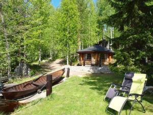 un cenador con un barco en el césped junto a una casa en Holiday Home Koivukallio by Interhome en Mataramäki