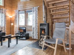 a living room with a fireplace in a log cabin at Holiday Home Pursiranta by Interhome in Keränen +15 photos