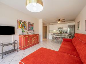 uma sala de estar com um sofá vermelho e uma cozinha em Apartment Eden Cap by Interhome em Antibes