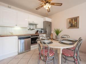 uma cozinha com uma mesa com cadeiras e uma ventoinha de tecto em Apartment Eden Cap by Interhome em Antibes