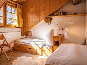 1 Schlafzimmer mit 2 Betten, einem Stuhl und einem Fenster in der Unterkunft Apartment Chesa Olgiati by Interhome in Celerina