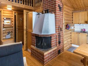 - un salon avec une cheminée en brique dans une cabane en rondins dans l'établissement Holiday Home Jänkäluppo i by Interhome, à Äkäslompolo