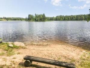 a bench sitting on the shore of a lake at Holiday Home Koivuranta by Interhome in Petäjävesi +9 photos