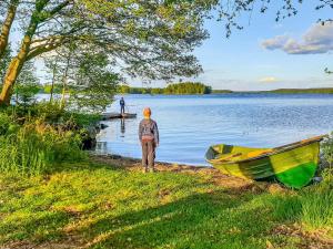 eine Person, die neben einem Boot auf einem See steht in der Unterkunft Holiday Home Haukiranta by Interhome in Kittilä